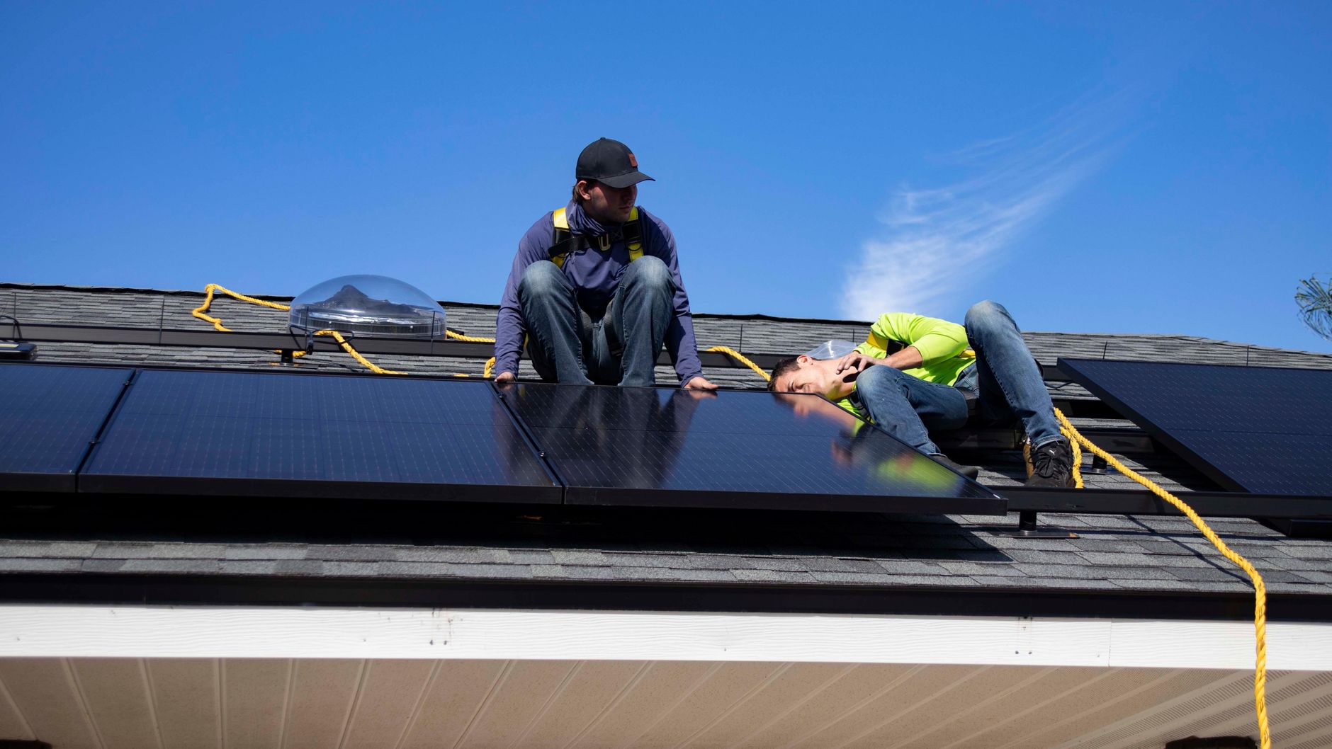 Monteurs plaatsen zonnepanelen op een woning